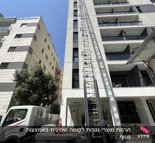 מנוף על משאית ליד בניין גבוה